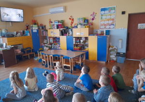 Dzieci oglądają film edukacyjny o wróblach.